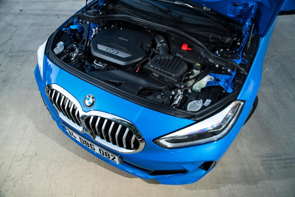 BMW bleue capot ouvert: Moteur TwinPower Turbo dévoilé BMW bleue capot ouvert, moteur TwinPower Turbo, logo BMW. Phares LED, grille avant et plaque 34 UBG 082 sur béton.